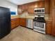 Well-lit kitchen featuring wooden cabinetry, stainless steel appliances, granite countertops, and tile flooring at 607 Park Ridge Cir, Marietta, GA 30068