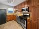 Well-lit kitchen featuring wooden cabinetry, stainless steel appliances, granite countertops, and tile flooring at 607 Park Ridge Cir, Marietta, GA 30068