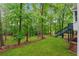 Backyard featuring a lush lawn and stairs leading to a wooden deck at 745 Greenvine Pl, Roswell, GA 30076