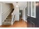 Inviting foyer featuring wood floors, a staircase with white banister, and a decorative pendant light at 745 Greenvine Pl, Roswell, GA 30076