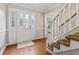 Foyer with wood flooring, decorative front door with glass panes, and staircase at 745 Greenvine Pl, Roswell, GA 30076