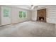 Spacious living room featuring a brick fireplace, built-in shelving, and neutral carpet at 745 Greenvine Pl, Roswell, GA 30076