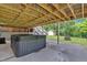 Covered back patio featuring a private hot tub, steps to an upper deck, with a yard backing to nature at 305 Devilla Trce, Fayetteville, GA 30214
