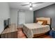Cozy bedroom with a queen-sized bed, modern ceiling fan, wood floors, and 'Be Our Guest' sign at 305 Devilla Trce, Fayetteville, GA 30214