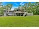 Expansive backyard view of a home with a spacious deck, covered patio, and lush lawn for outdoor enjoyment at 305 Devilla Trce, Fayetteville, GA 30214