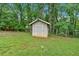 Storage shed in the backyard provides outdoor storage space for gardening and equipment, with a lawn at 305 Devilla Trce, Fayetteville, GA 30214