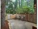 Backyard patio featuring string lights, seating, and a fenced yard with mature trees at 3119 Colonial Way # H, Atlanta, GA 30341