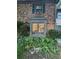 Charming brick house exterior with bay window, shuttered window and lush landscaping at 3119 Colonial Way # H, Atlanta, GA 30341