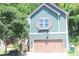 Charming home featuring green siding, a brown garage door, and a window box filled with flowers at 313 India Ln, Canton, GA 30114