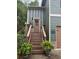 Inviting front entrance featuring a wooden staircase, decorative plants, and a stylish door with a wreath at 313 India Ln, Canton, GA 30114