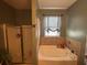 Main bathroom featuring a soaking tub, glass enclosed shower, and tile accents at 313 India Ln, Canton, GA 30114