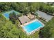 Aerial showcasing pool, tennis courts, playground, parking surrounded by mature trees at 4561 Jenkins Way, Douglasville, GA 30135