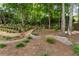 Beautifully landscaped backyard with a terraced garden, mature trees, and cozy swing area at 4561 Jenkins Way, Douglasville, GA 30135