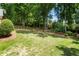 Picturesque backyard features a large lawn, terraced garden, mature trees, and a charming swing set at 4561 Jenkins Way, Douglasville, GA 30135