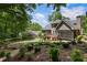 Lush backyard with terraced garden, mature trees, a swing, and outdoor seating area, ideal for entertaining at 4561 Jenkins Way, Douglasville, GA 30135