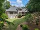 Overhead backyard featuring mature trees, terraced garden, a wooden deck, and vinyl siding at 4561 Jenkins Way, Douglasville, GA 30135
