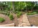 Terraced garden with a swing, mature trees, and lush greenery, perfect for relaxation and outdoor enjoyment at 4561 Jenkins Way, Douglasville, GA 30135