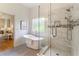 Modern bathroom features a soaking tub, glass-enclosed shower, and tiled floors for an upscale and serene atmosphere at 4561 Jenkins Way, Douglasville, GA 30135