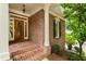Inviting front porch with a wooden door, brick steps, and white columns, creating a welcoming entrance at 4561 Jenkins Way, Douglasville, GA 30135
