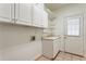 Bright laundry room features tile flooring, storage cabinets, shelving, sink, and exterior access door at 4561 Jenkins Way, Douglasville, GA 30135