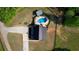 Aerial view of a house with a pool, surrounded by green fields and a gravel driveway at 540 Benton Rd, Covington, GA 30014