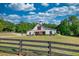 Classic white barn-style home with a striking gabled roof, surrounded by a well-maintained lawn at 540 Benton Rd, Covington, GA 30014