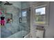 Modern bathroom features a glass-enclosed shower with gray tile and natural light at 540 Benton Rd, Covington, GA 30014