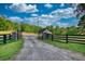 Gravel driveway leading to a home, framed by stone pillars and a secure metal gate at 540 Benton Rd, Covington, GA 30014