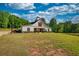 Charming barn-style house with lush green lawn and covered porch perfect for relaxing outdoors at 540 Benton Rd, Covington, GA 30014