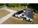 Aerial view showcasing the home's exterior, complete with a black roof, modern design, and a well-maintained driveway at 540 Benton Rd, Covington, GA 30014