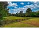 Lush green pasture enclosed by a wooden fence, offering ample space for grazing or recreation at 540 Benton Rd, Covington, GA 30014