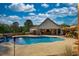 Backyard pool with outdoor dining area, wooded surroundings, and a sunny sky at 540 Benton Rd, Covington, GA 30014
