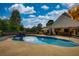 Backyard pool with outdoor dining area, wooded surroundings, and a sunny sky at 540 Benton Rd, Covington, GA 30014