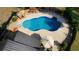 Aerial view of a kidney-shaped pool surrounded by a concrete patio, lounge chairs, and lush landscaping at 540 Benton Rd, Covington, GA 30014