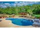 Backyard pool with lounge chairs, wooded surroundings, pergola with bar, and a sunny sky at 540 Benton Rd, Covington, GA 30014
