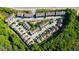 An aerial view of a neighborhood showcasing modern townhomes surrounded by mature trees and lush landscaping at 9872 Cameron Parc Cir, Johns Creek, GA 30022