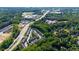 An aerial view of a community surrounded by lush greenery and a view of nearby shops and schools at 9872 Cameron Parc Cir, Johns Creek, GA 30022
