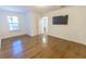 Bright bedroom with hardwood floors, a large window, and mounted television at 9872 Cameron Parc Cir, Johns Creek, GA 30022