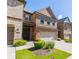 Charming brick townhome with a dark wood front door and well-maintained lawn at 9872 Cameron Parc Cir, Johns Creek, GA 30022