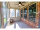 Inviting sunroom with brick accent wall, wood-look floors, ceiling fan, and multiple windows offering natural light at 9872 Cameron Parc Cir, Johns Creek, GA 30022