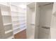 A spacious walk-in closet with custom white shelving and rods for optimal storage and organization at 9872 Cameron Parc Cir, Johns Creek, GA 30022