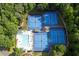 An aerial view of a tennis court with a swimming pool surrounded by mature green trees at 1105 Anemone Nw Way, Acworth, GA 30102