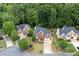 An aerial view showcasing the lush landscaping surrounding the elegant brick home in a wooded neighborhood at 1105 Anemone Nw Way, Acworth, GA 30102