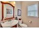Powder room featuring a white sink, framed mirror, commode, and framed art at 1105 Anemone Nw Way, Acworth, GA 30102