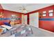 Bedroom featuring red walls, a blue stripe, carpet, a ceiling fan, and double closet doors at 1105 Anemone Nw Way, Acworth, GA 30102
