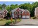 Attractive brick home displays a well-kept lawn, mature trees, and a convenient two-car garage at 1105 Anemone Nw Way, Acworth, GA 30102