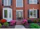 Elegant home entrance with a beautiful door, complemented by colorful flowers and manicured landscaping at 1105 Anemone Nw Way, Acworth, GA 30102