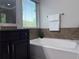 Bright bathroom with a soaking tub, tiled walls, and a large window at 1632 Lenox Overlook Ne Rd, Brookhaven, GA 30329