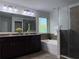 Well-lit bathroom with double vanity, soaking tub, and a separate glass shower at 1632 Lenox Overlook Ne Rd, Brookhaven, GA 30329