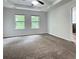 Spacious bedroom with plush carpet, tray ceilings, and windows with natural light at 1632 Lenox Overlook Ne Rd, Brookhaven, GA 30329
